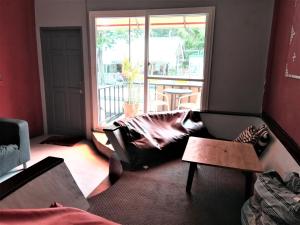 a living room with a couch and a window at Red Samed Party House in Ko Samed