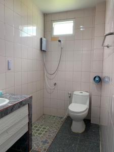 uma casa de banho com um chuveiro, um WC e um lavatório. em KritshanaJPR 3 K Hotel em Trat