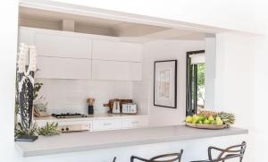 a kitchen with white cabinets and a bowl of fruit on a counter at Akoakoa - Sunrise Beach in Sunrise Beach