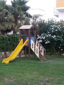 a playground with a slide in the grass at Residence Rivamare Ugento in Torre Mozza
