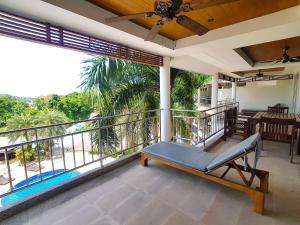 a porch with a bench on a balcony at Spacious apartment with Ocean view in Panwa in Phuket Town