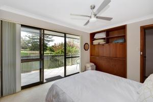 a bedroom with a bed and a balcony at Fi's relaxing Beach House in Port Macquarie