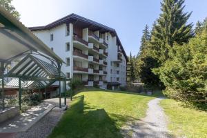 an apartment building with a lawn in front of it at Chalet Belmont in Flims