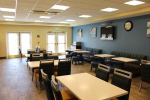 a dining room with tables and chairs and a clock on the wall at Best Western Plus Lake Elsinore Inn & Suites in Lake Elsinore