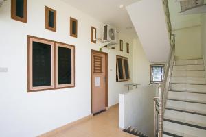 a hallway with a staircase in a house at RedDoorz @ Pematangsiantar 2 in Pematangsiantar