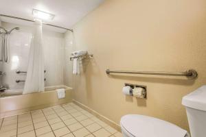 a bathroom with a toilet and a tub and a shower at Econo Lodge North in Charleston