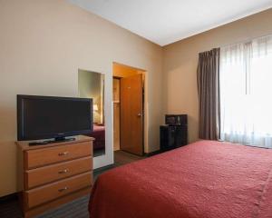 a hotel room with a bed and a flat screen tv at Quality Inn Joplin I-44 in Joplin