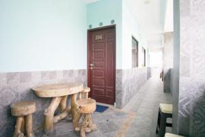 une chambre avec une table en bois et deux tabourets dans l'établissement RedDoorz near Mikie Holiday Funland Berastagi, à Berastagi