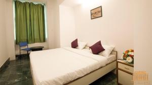 sypialnia z białym łóżkiem i zieloną zasłoną w obiekcie Hotel Townhall w mieście Bengaluru