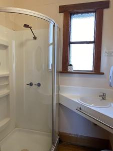 uma casa de banho com um chuveiro e um lavatório. em Shipwrights Arms Hotel em Hobart