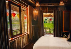 a bedroom with a bed and a window with a view at Mua Caves Ecolodge (Hang Mua) in Ninh Binh