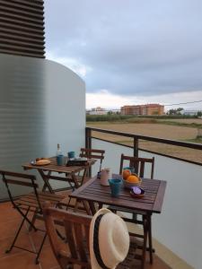 2 tafels en stoelen op een balkon met uitzicht bij Deltebre Apartamentos in Deltebre