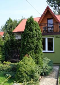 un gran arbusto verde frente a una casa en Domek Gloria nad Jeziorem Żywieckim en Żywiec