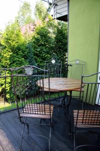 a wooden table and chairs on a porch at Domek Gloria nad Jeziorem Żywieckim in Żywiec