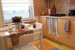 a kitchen with a table and two chairs and a table and a kitchen at Amazing view apartment in Jelgava