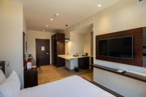 a hotel room with a large television on the wall at The Compass Hotel in Amman