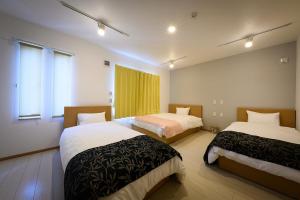 a hotel room with two beds and a window at SAKURA93 in Sapporo