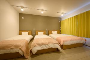 a room with three beds in a room at SAKURA93 in Sapporo