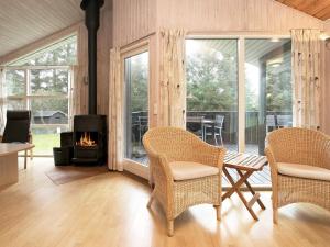 sala de estar con 2 sillas y chimenea en 8 person holiday home in Hj rring, en Hjørring