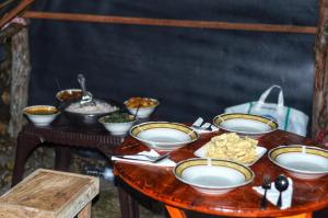a table with bowls and plates of food on it at Eco Lodge Haputale-Camping Sri lanka in Haputale