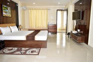 um quarto de hotel com uma cama e uma televisão em Roopkatha Hotel Kalimpong em Kalimpong