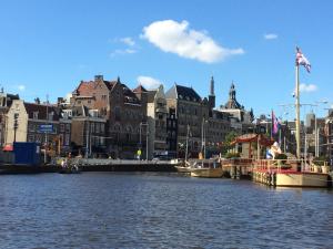 a river with boats in a city with buildings at Cozy Canal Studio in Amsterdam