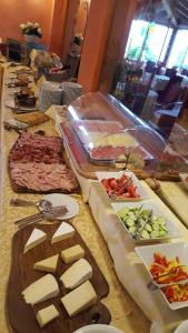 a buffet with cheese and other foods on a table at Hotel Diana in San Zeno di Montagna +52 photos