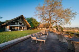 une rangée de chaises assises sur une terrasse en bois dans l'établissement Buckler's Africa Lodge Kruger Park, à Komatipoort