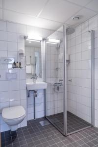 a bathroom with a toilet and a sink and a shower at Hotel Sverre in Sandnes