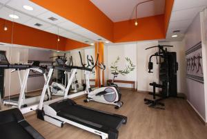 a gym with several treadmills and elliptical machines at Evripides Hotel in Athens