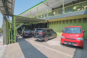 een groep auto's geparkeerd voor een gebouw bij RedDoorz Syariah near Museum Wisma Karya Subang in Subang