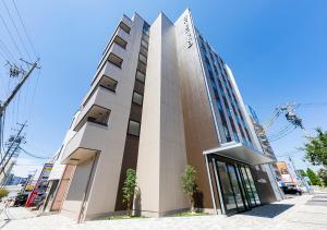 un edificio alto con un cartel en él en Hotel Trend Mikawaanjo, en Anjomachi