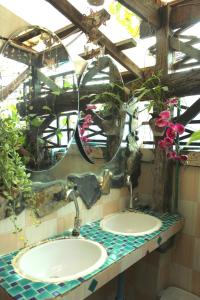 Baño con 2 lavabos, espejo y plantas en Shanti Lodge, en Bangkok