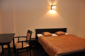 een slaapkamer met een bed, een bureau en een lamp bij Villa Szamocin in Warschau