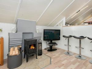 a living room with a fireplace and a tv at 8 person holiday home in Hemmet in Hemmet