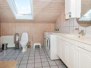 a bathroom with a washing machine and a toilet at 8 person holiday home in Hemmet in Hemmet