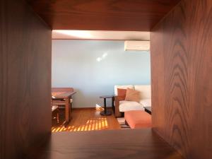 mit Blick auf ein Wohnzimmer mit einem Sofa und einem Tisch in der Unterkunft La Krasse Angelroad in Tonosho