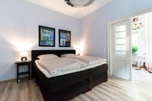 1 dormitorio con 1 cama grande con sábanas blancas en Ferienwohnung Bispink, en Wilsum