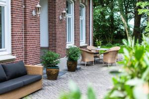 a patio with a couch and chairs and a table at Ferienwohnung Bispink in Wilsum