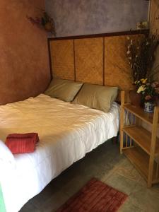 a bed with a wooden headboard in a room at Shanti Lodge in Bangkok