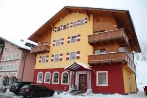 un gran edificio con nieve en el suelo delante de él en Hotel Tauernblick en Obertauern