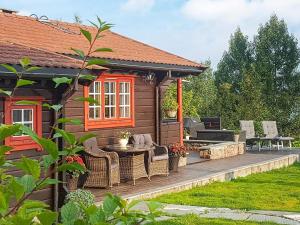 a cabin with a deck with a table and chairs at 6 person holiday home in Frei in Frei