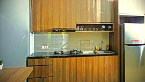 a kitchen with a sink and a refrigerator at HM SOCIAL Karawaci in Tangerang