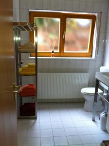 ein Bad mit einem Fenster, einem Waschbecken und einem WC in der Unterkunft A Little Home in Rust