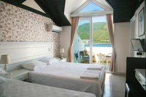 a hotel room with two beds and a window at Hotel Chateau de Ville in Marmaris