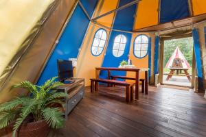 a room with a table and a tv in a dome house at Vakantiepark de Bergen in Wanroij