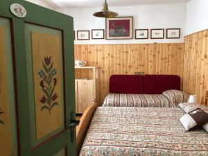 een slaapkamer met 2 bedden en een groene deur bij CA' POGGIOLO in Pieve di Cadore