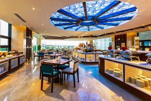 um restaurante com um grande tecto de vidro azul em Maximilan Danang Beach Hotel em Da Nang