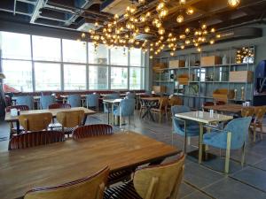 um restaurante com mesas e cadeiras de madeira e janelas em Teknosports Otel em Istambul