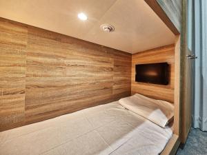 那霸的住宿－CABIN&HOTEL ReTIME，一间卧室配有一张床,墙上配有电视